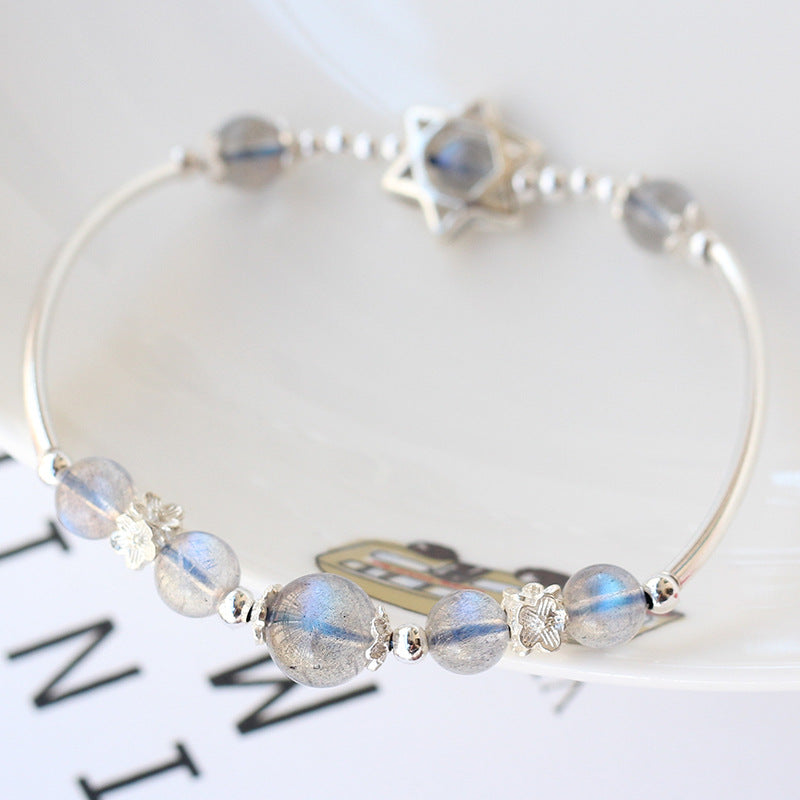 Silver bracelet with beaded design on a white background