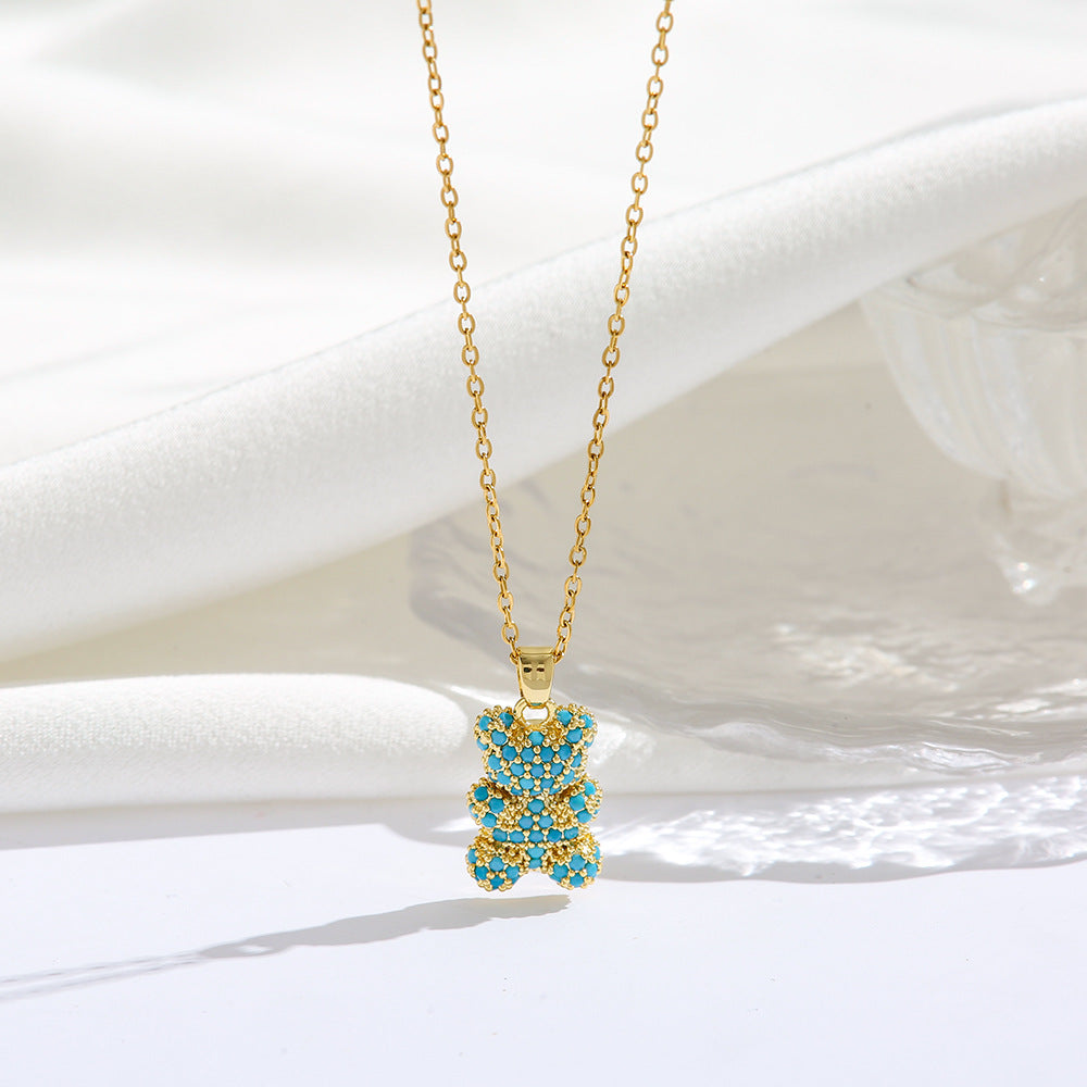 Gold necklace with a blue pendant on a white background
