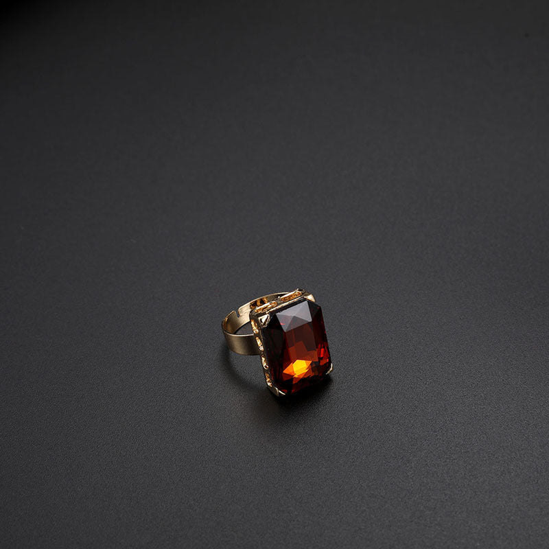 Gold ring with a rectangular red gemstone on a dark gray background