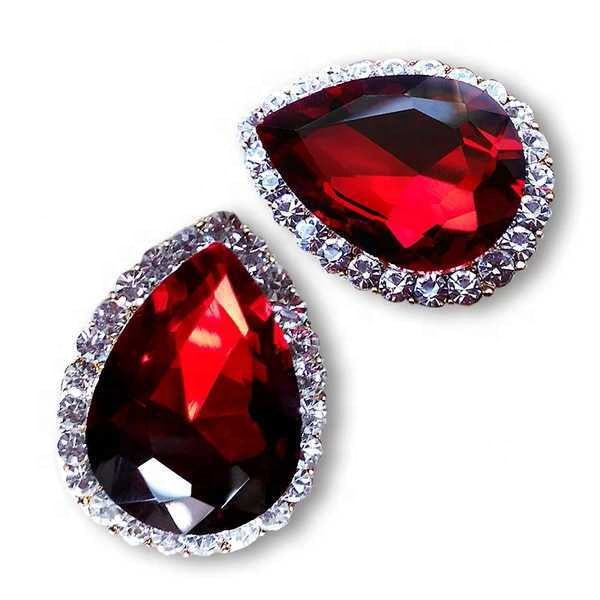 Pair of earrings with red gemstones and silver accents on a white background