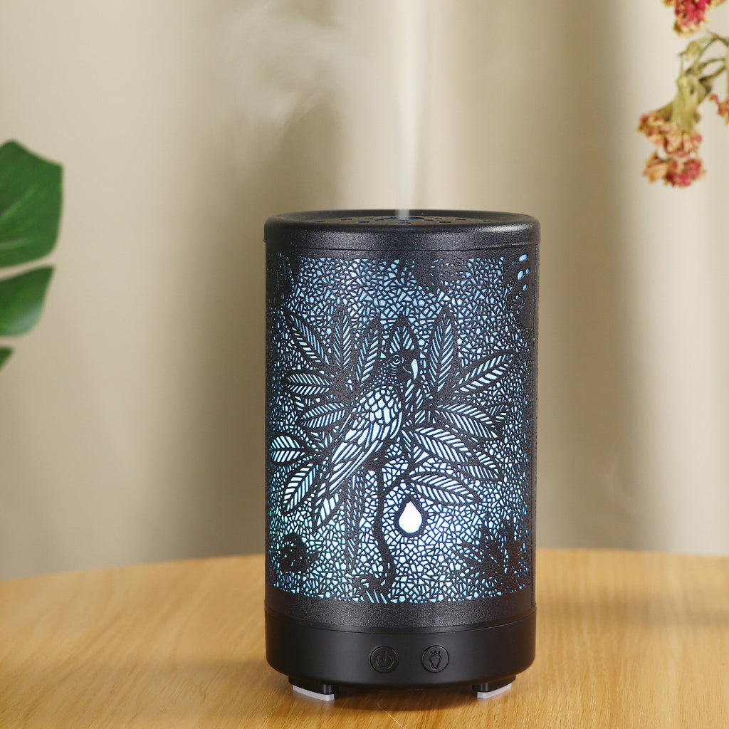Decorative diffuser with leaf pattern on a wooden surface