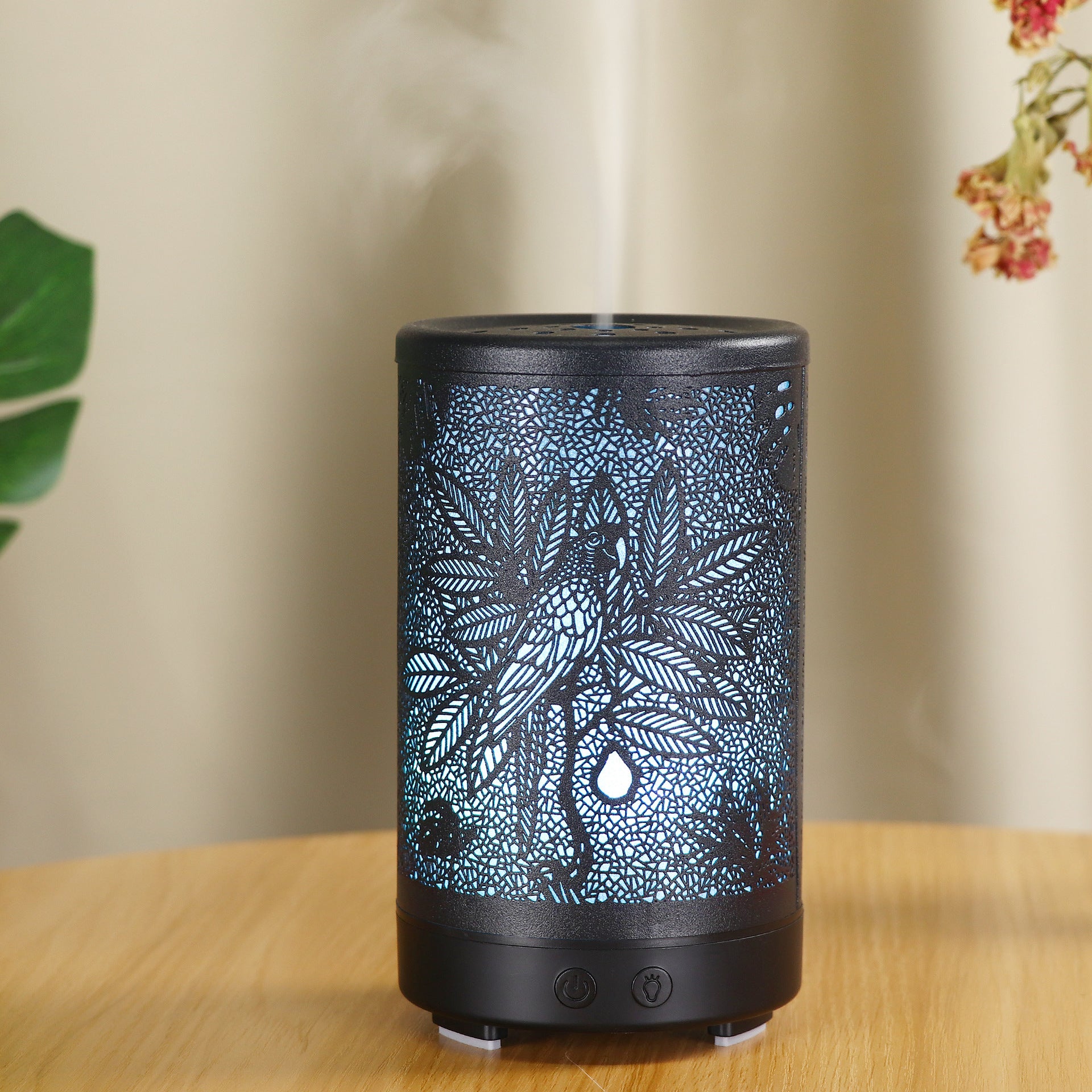 Decorative diffuser with leaf pattern on a wooden surface