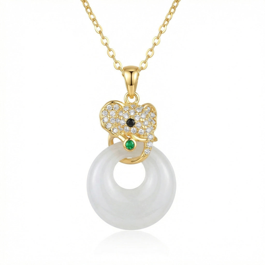 Gold pendant necklace with a white pearl and green gemstone on a white background
