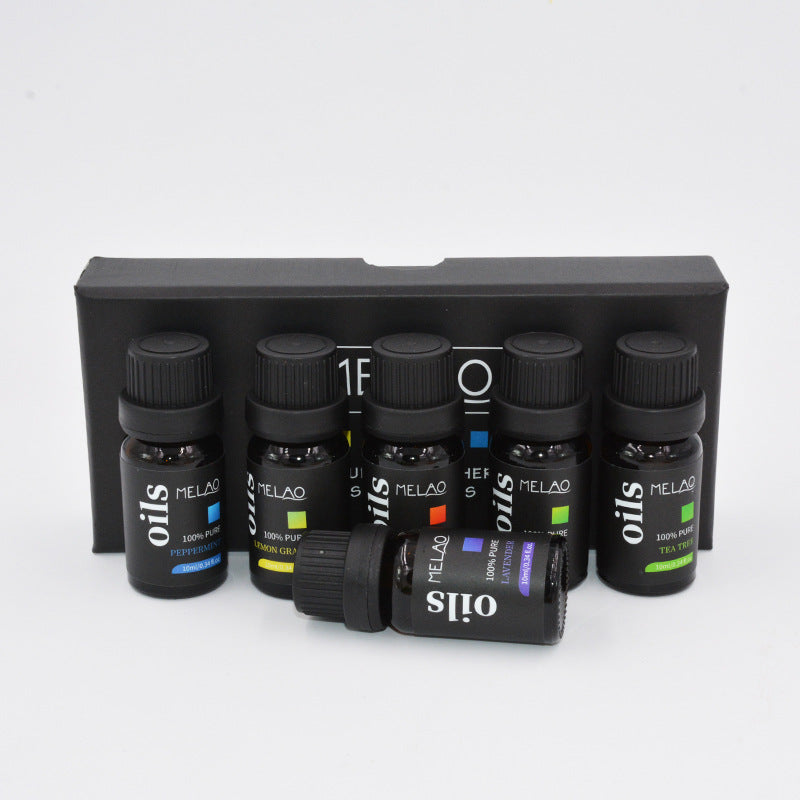 Set of MELAQ oils bottles in a black holder on a white background