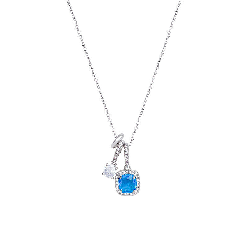 Silver necklace with a blue gemstone pendant on a white background