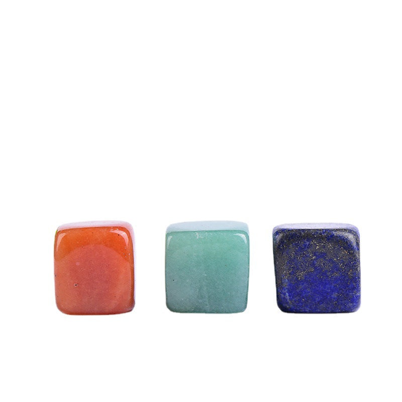 Three square stones in orange, green, and blue on a white background
