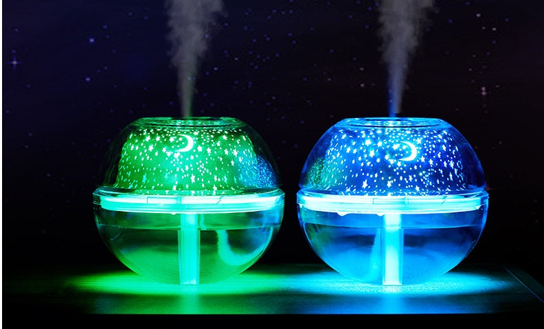 Two glowing spherical devices emitting mist on a dark background