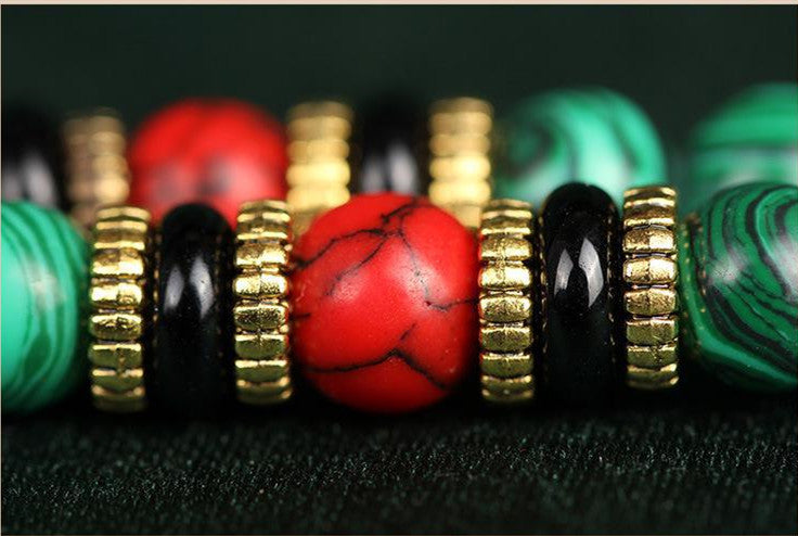 Colorful beads with gold accents on a dark fabric background