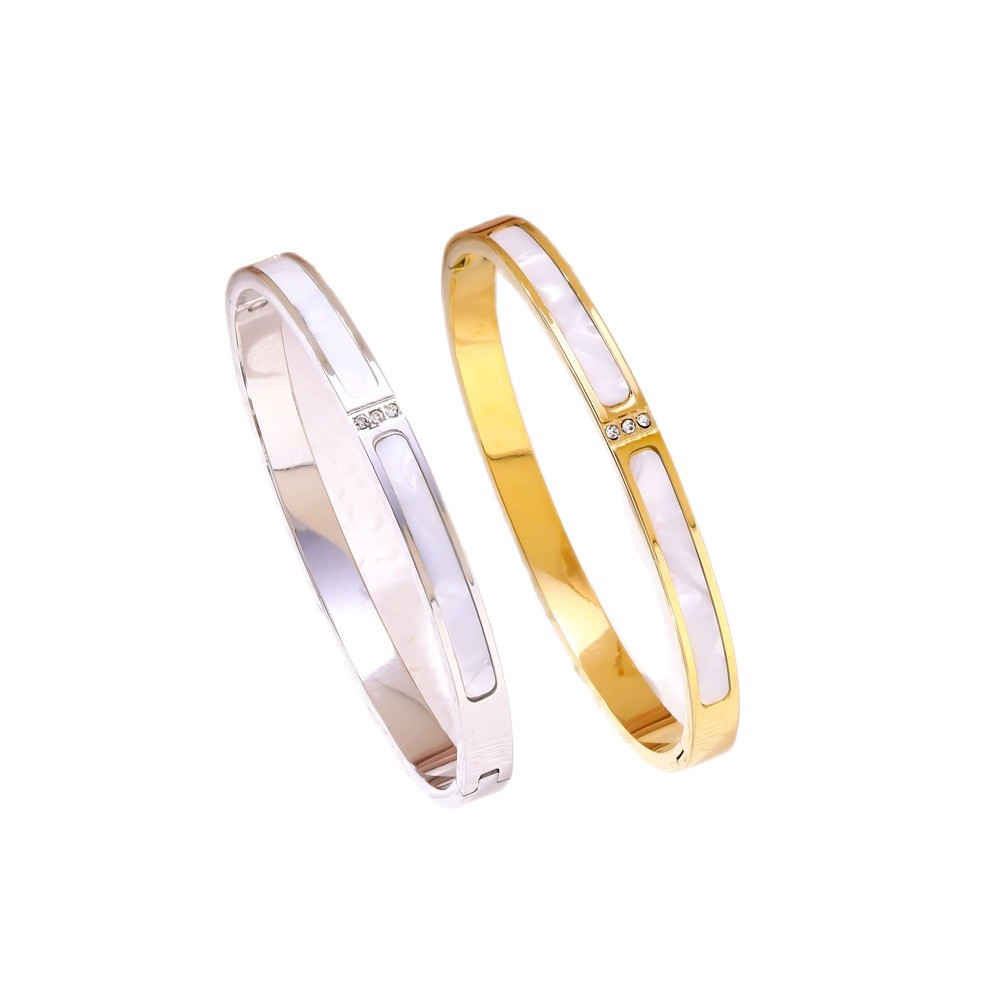 Two gold and silver bangles on a white background