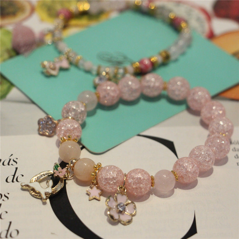 Pink beaded bracelet with charms on a magazine page