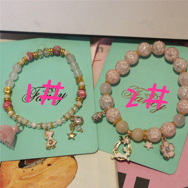 Two beaded bracelets with charms on green cards with 'Fancy' branding.