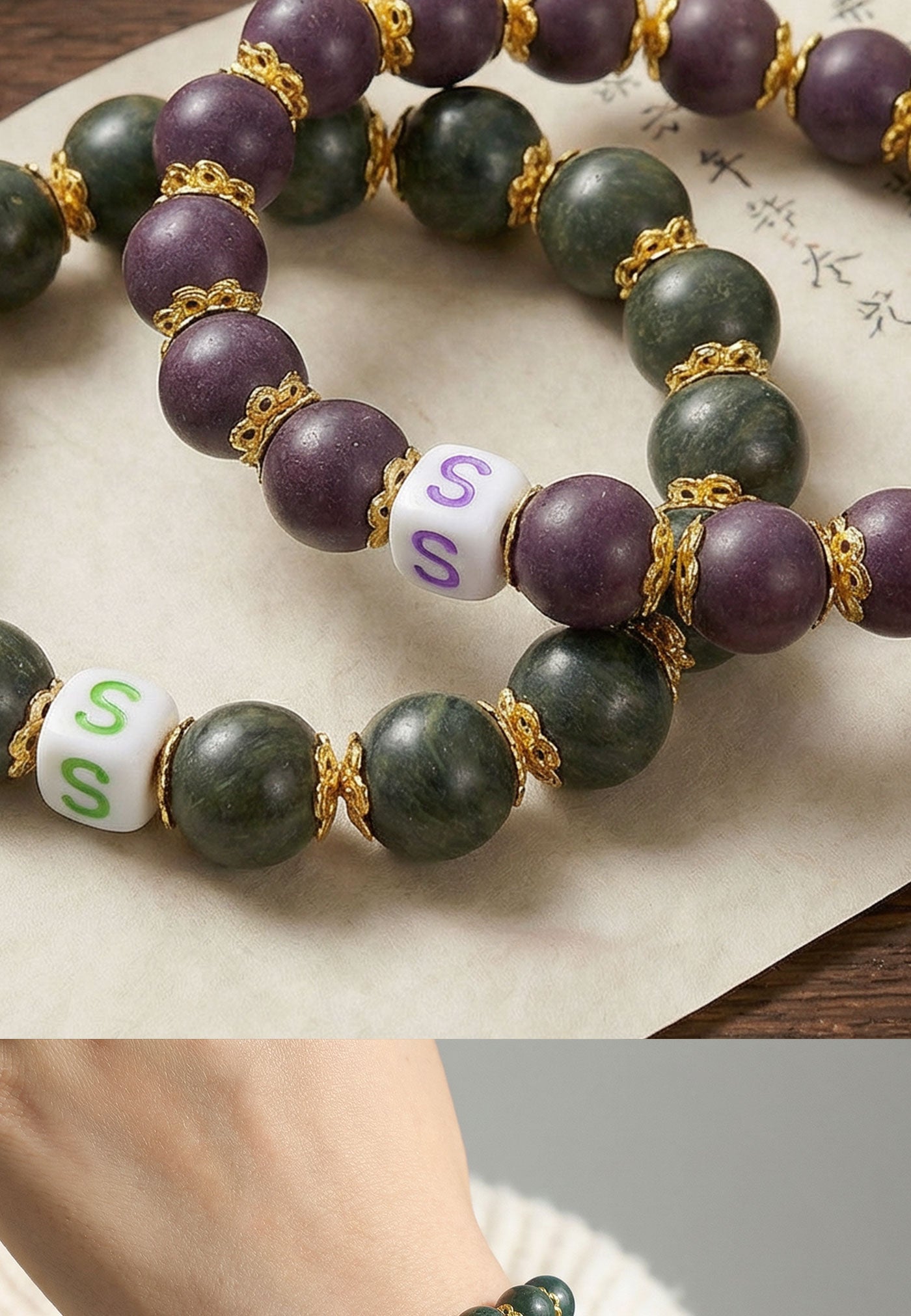 Bracelet with purple and green beads and letter 'S' beads on a textured surface.