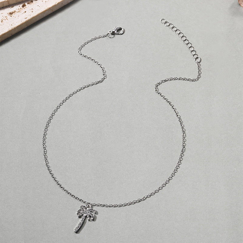 Silver necklace with a small pendant on a light gray surface