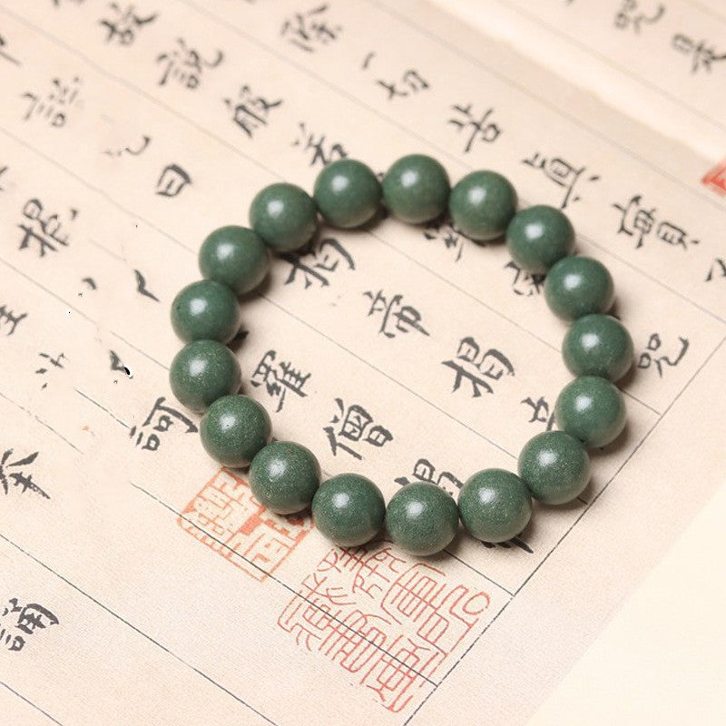 Green beaded bracelet on a piece of paper with Chinese characters