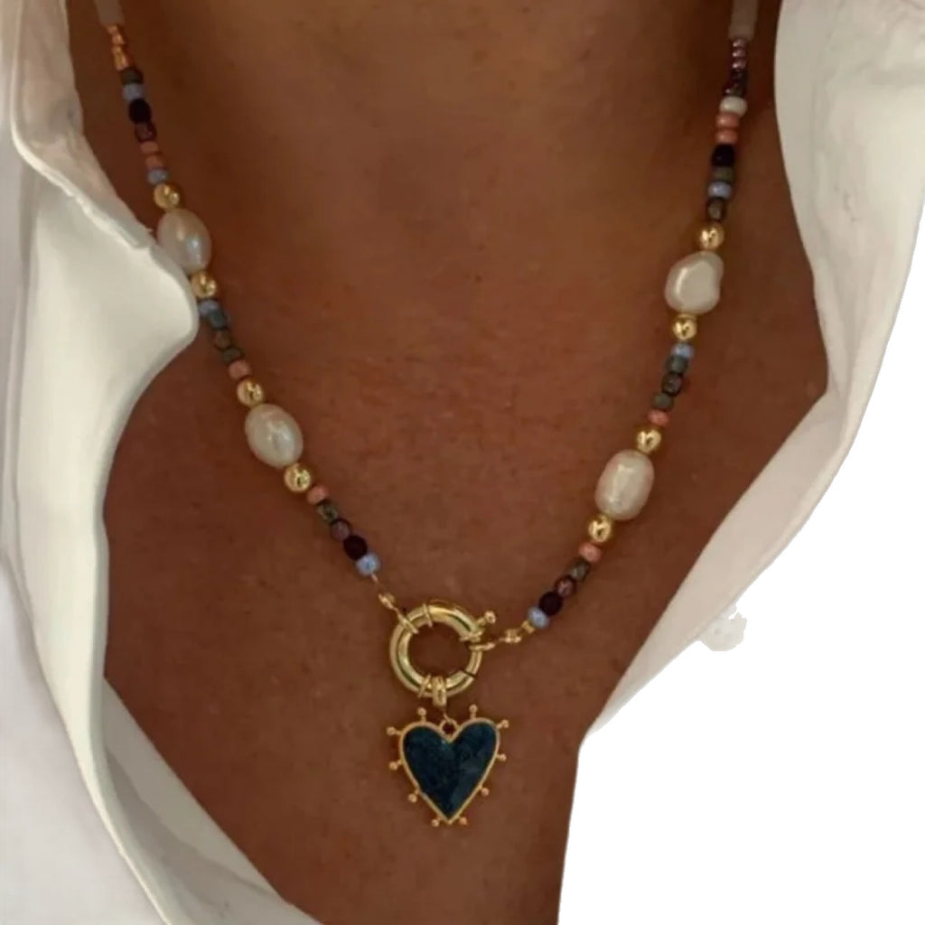 Necklace with heart pendant and multicolored beads on a person's neck