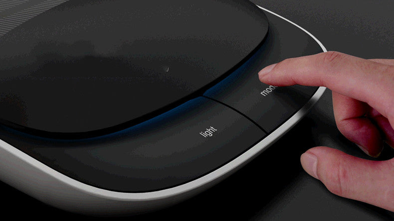 Hand pressing a button on a modern electronic device with 'light' indicator.