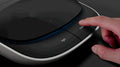 Hand pressing a button on a modern electronic device with 'light' indicator.