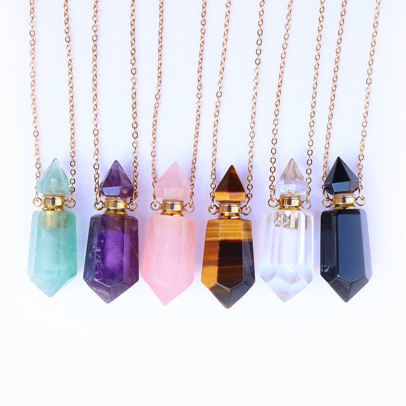 Set of crystal pendant necklaces on gold chains against a white background