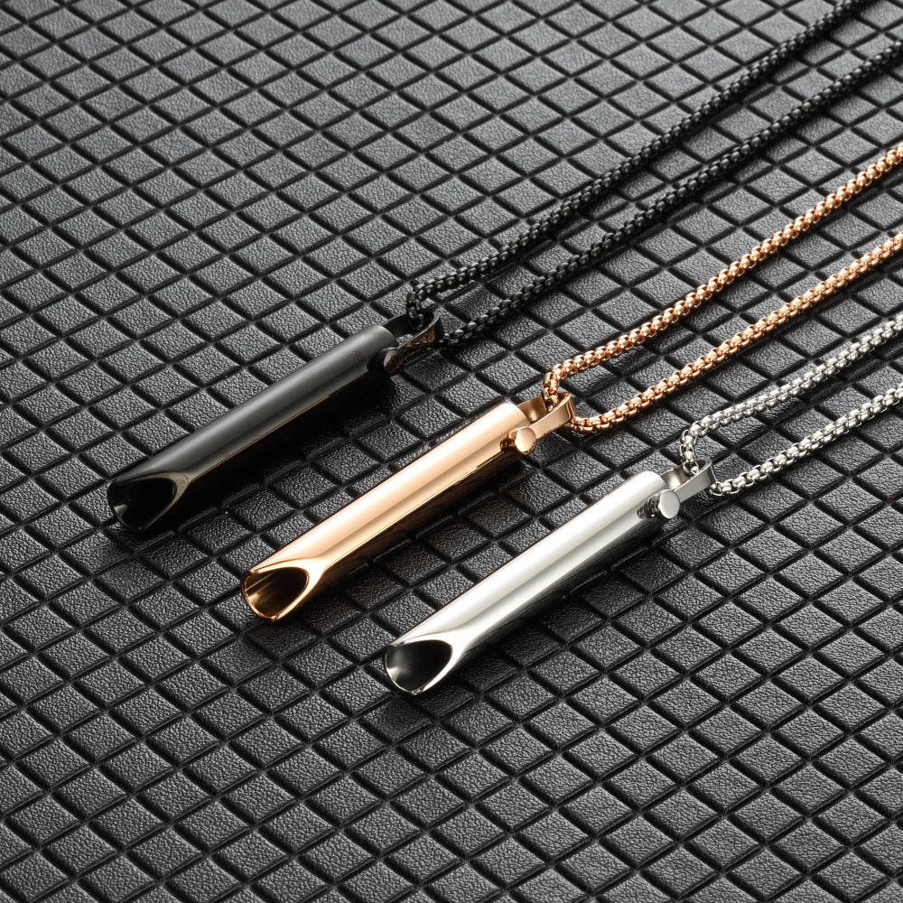 Three necklaces with different colored pendants on a textured black surface