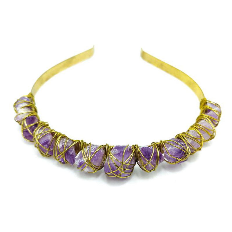 Gold headband with purple gemstones on a white background