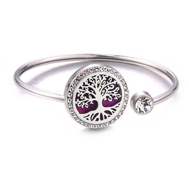 Silver bracelet with a purple tree of life charm on a white background
