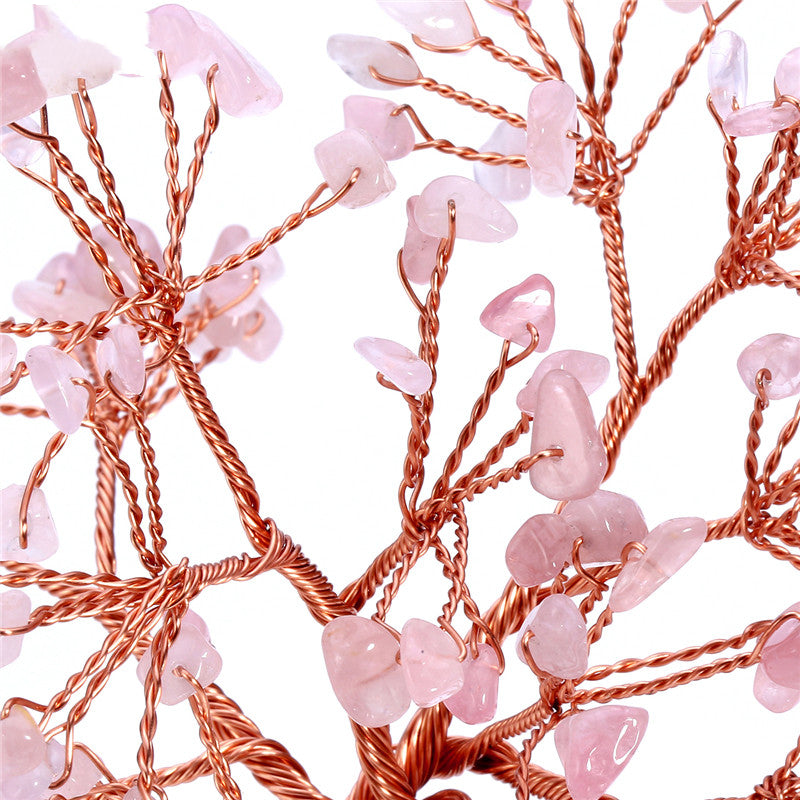 Decorative string lights with pink beads and copper wire on a white background