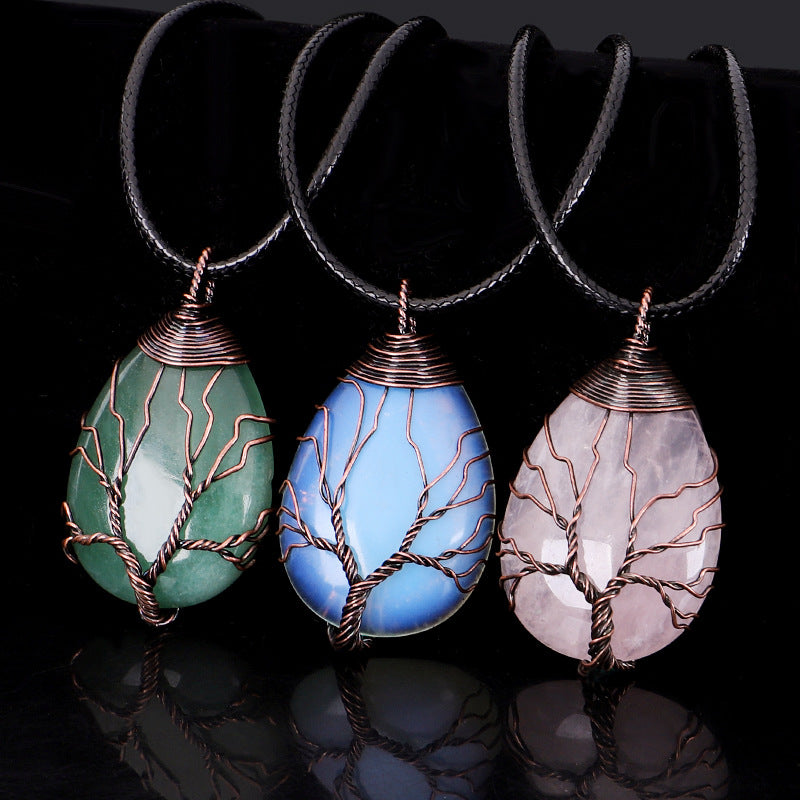 Three teardrop-shaped stone pendants with wire wrapping on a black background