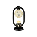 Black lantern-shaped candle holder with a lit candle inside on a white background