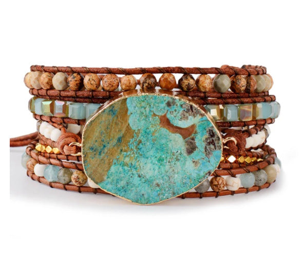 Multistrand beaded bracelet with a large turquoise stone on a white background