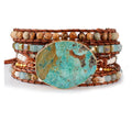 Multistrand beaded bracelet with a large turquoise stone on a white background