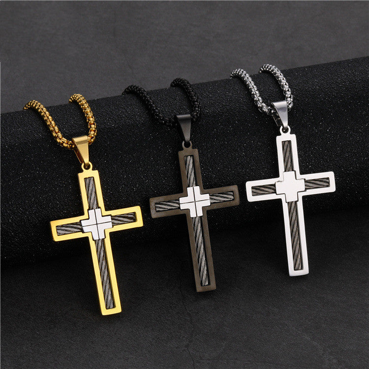 Three cross-shaped pendants on black ribbons against a dark background