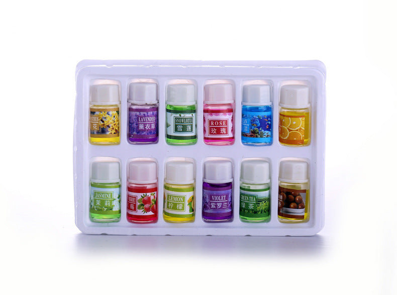 Set of small bottles with colorful labels in a white box on a white background