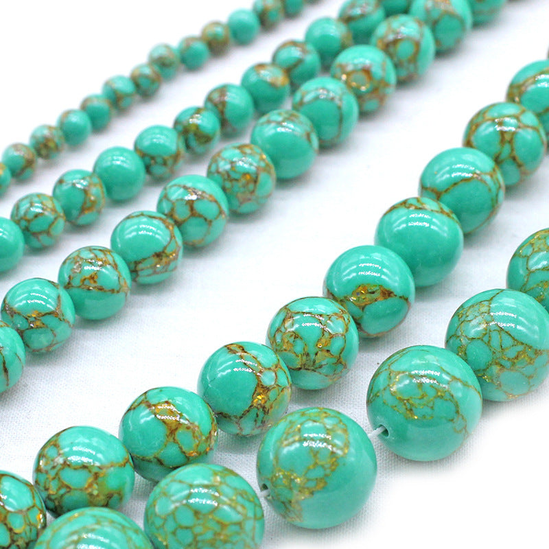 Turquoise beads with gold speckles on a white background