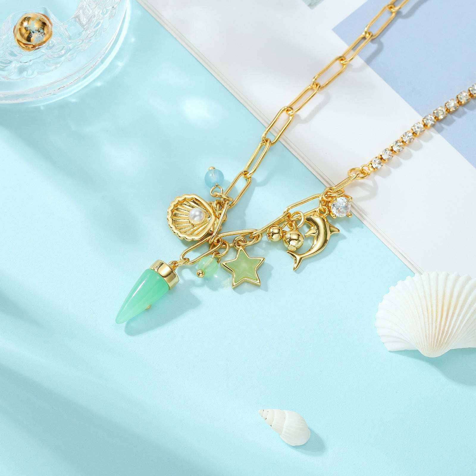 Gold necklace with charms on a light blue background