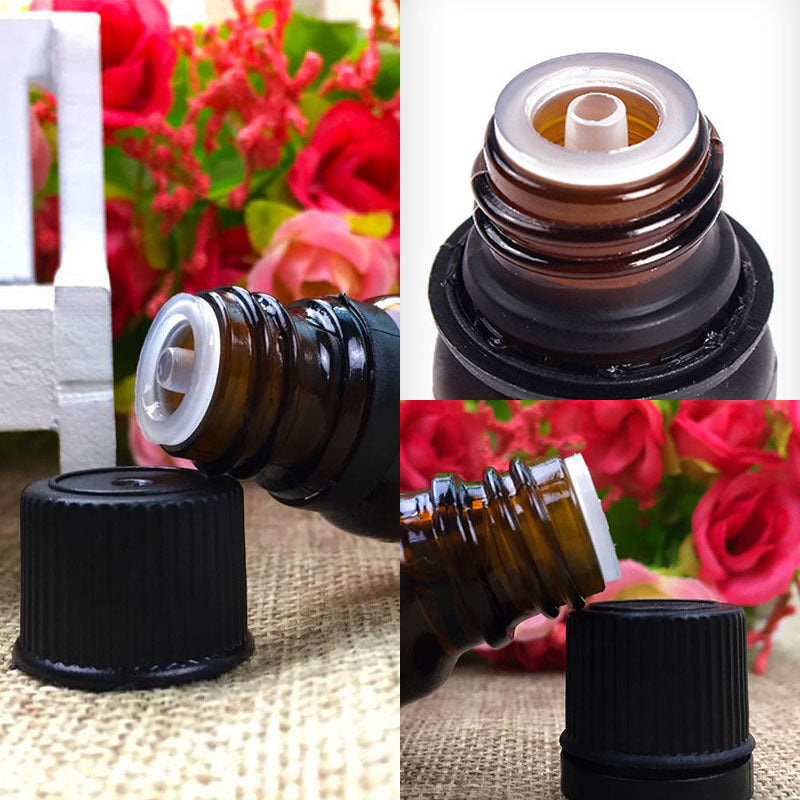 Close-up of an essential oil bottle with a black cap against a floral background