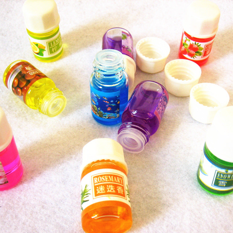 Assorted small bottles with colorful labels on a textured surface