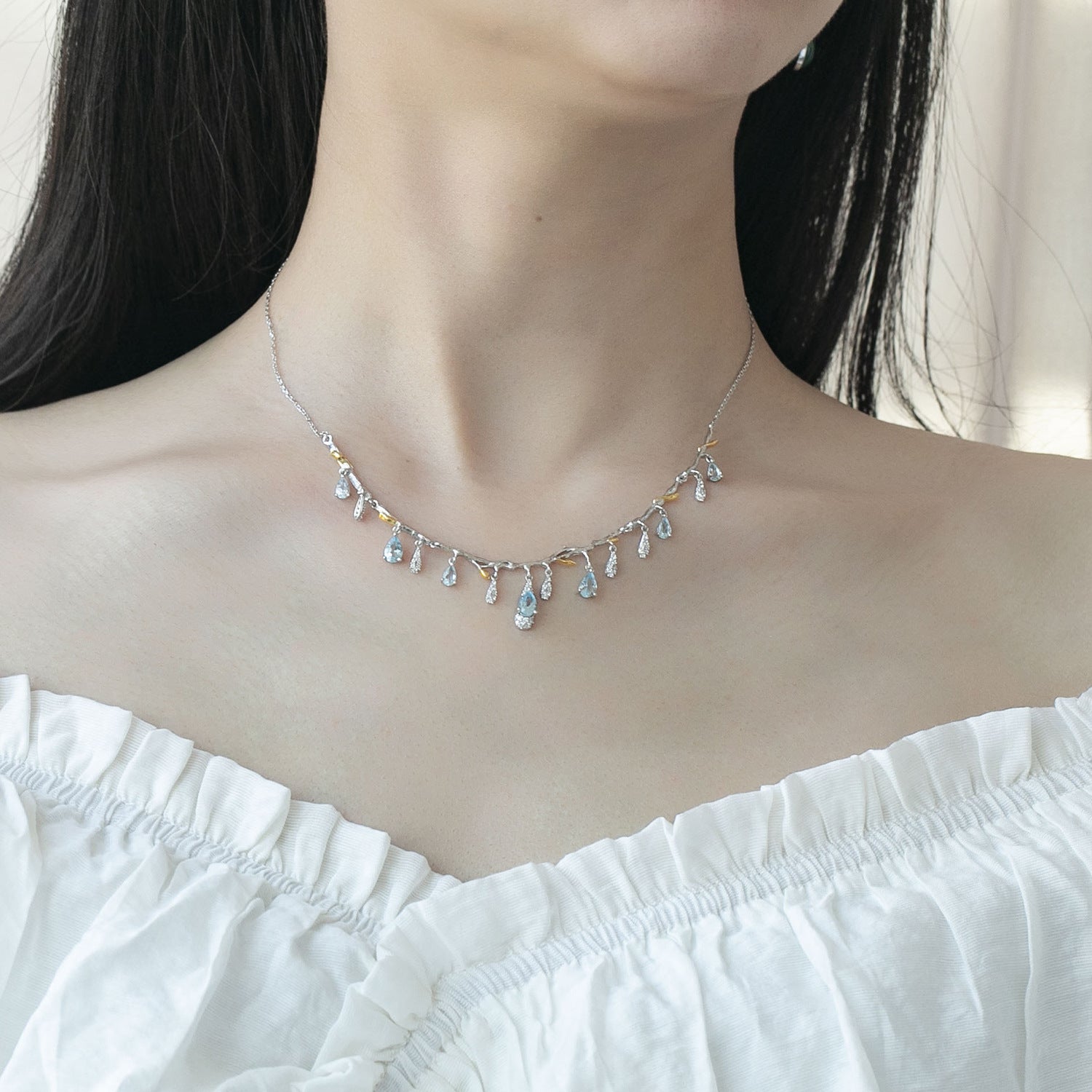 Necklace with small, colorful beads worn by a person against a neutral background