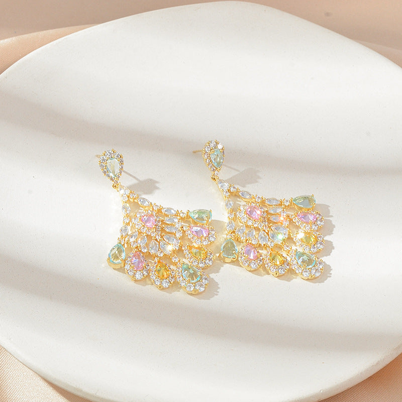 Gold earrings with colorful gemstones on a white surface
