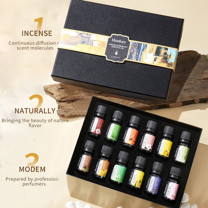 Set of essential oil bottles in a black box with a brand label, placed on a wooden surface.