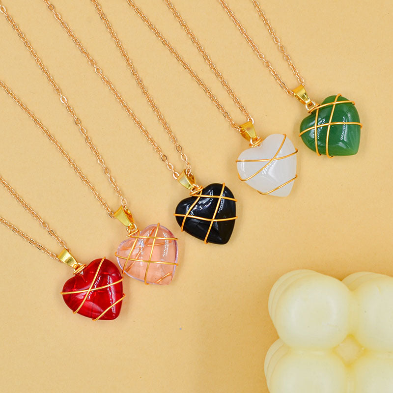 Heart-shaped stone necklaces with gold chains on a yellow background