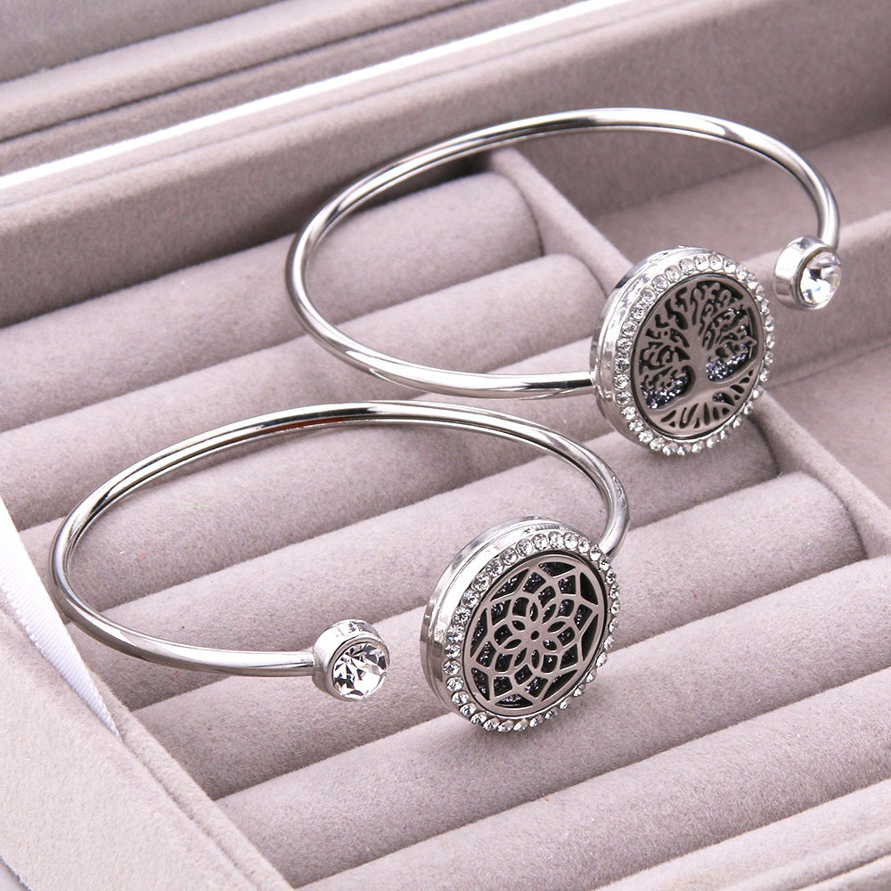 Silver bangles with intricate designs on a pink jewelry box