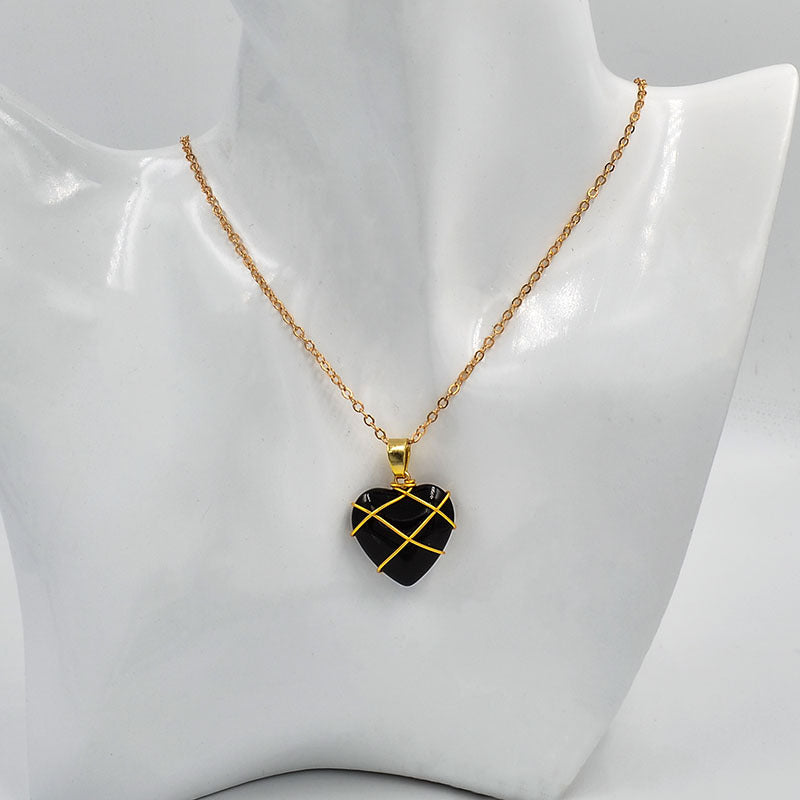 Necklace with a black heart-shaped pendant on a mannequin bust.