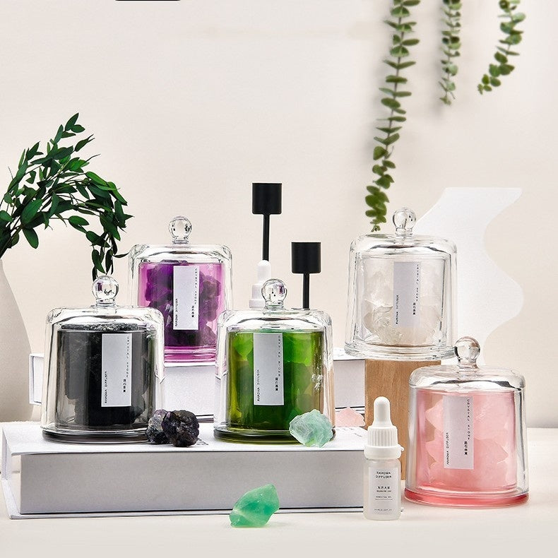 Collection of glass jars with various contents on a white surface with plants in the background