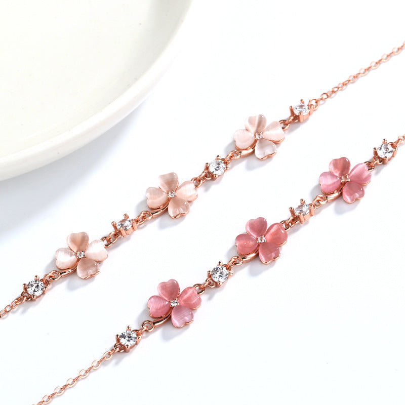 Delicate floral necklace with pink flowers and rose gold chain on a white background