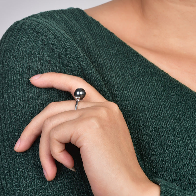 Close-up of a hand wearing a ring on a green textured fabric background