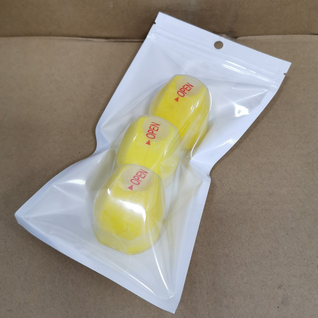 Two yellow items with 'OPEN' labels on a clear plastic bag against a brown cardboard background.