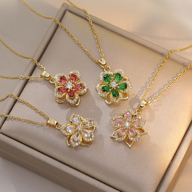 Gold necklaces with floral pendants on a beige surface