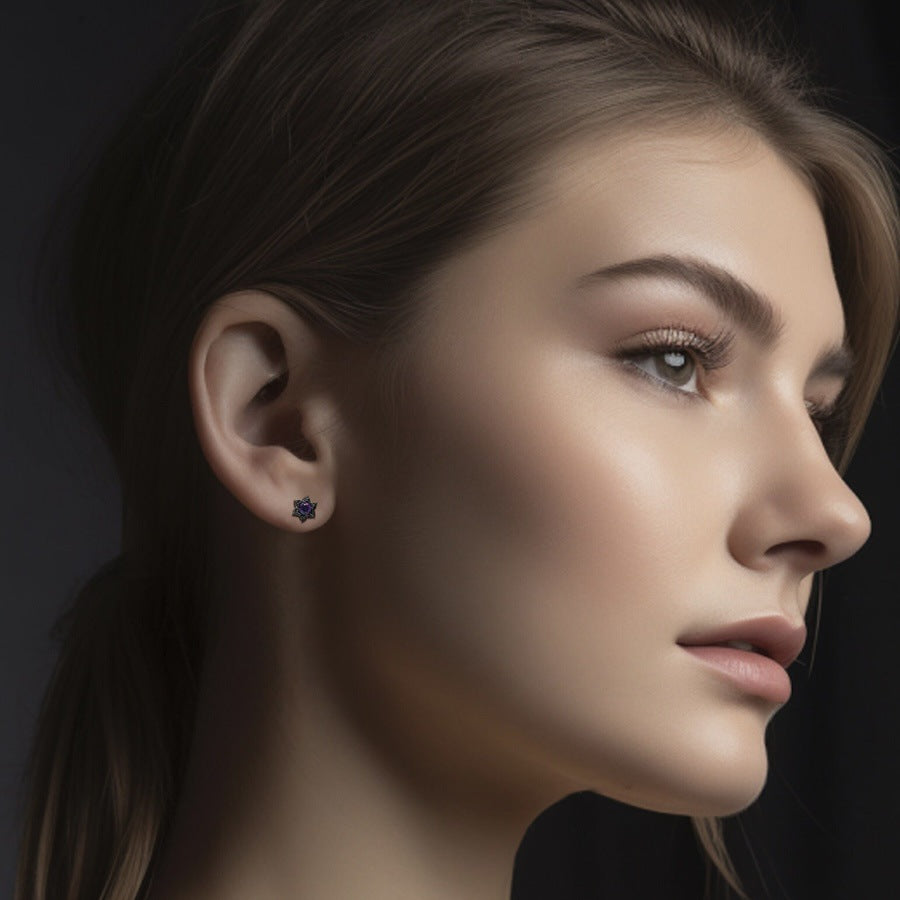 Close-up of a woman wearing a floral earring against a dark background