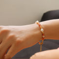 Close-up of a wrist wearing a bracelet with beads on a neutral background