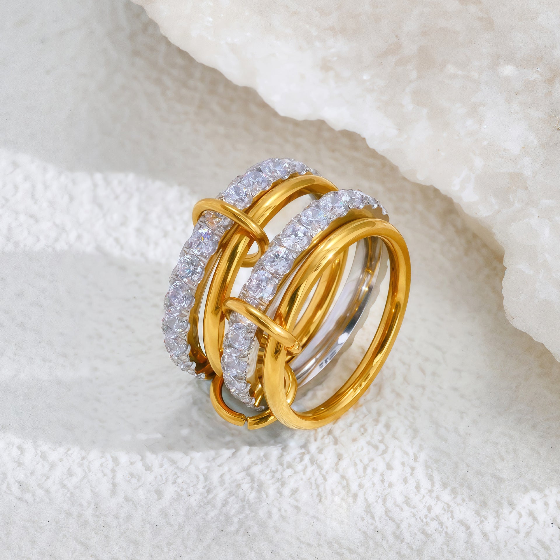 Gold and diamond ring on a textured white surface